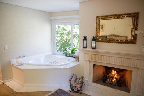 a bathroom with a tub and a fireplace at Locanda della Mimosa in Petrópolis