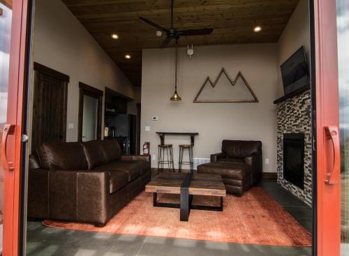a living room with two leather couches and a fireplace at Royal Gorge Cabins in Buckskin Joe
