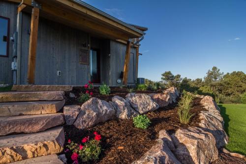 a garden with rocks and flowers in front of a house at Royal Gorge Cabins in Buckskin Joe
