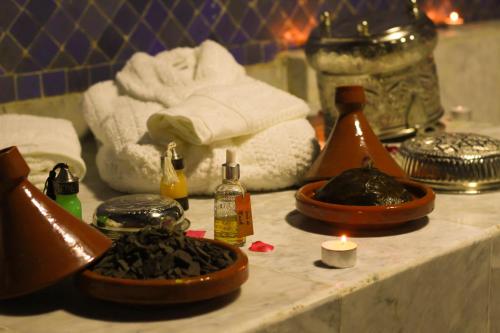 a bathroom counter with a sink with towels and a candle at Palais Houyam in Fès