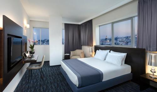 a hotel room with a bed and a large window at Golden Crown Old City Hotel in Nazareth