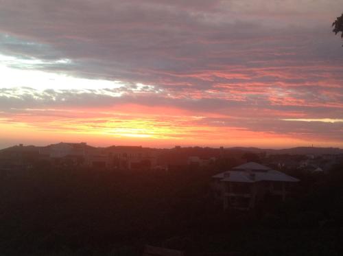 a sunset over a city with buildings in the foreground at Pezula Golf House in Knysna
