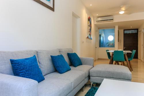 a living room with a gray couch and blue pillows at Papaya 15 Apartments in Playa del Carmen