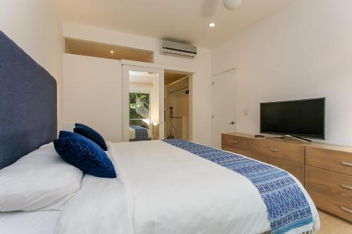 a bedroom with a large bed with a television at Papaya 15 Apartments in Playa del Carmen