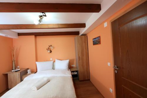 a bedroom with orange walls and a large bed at Sobe Grabar in Ptuj