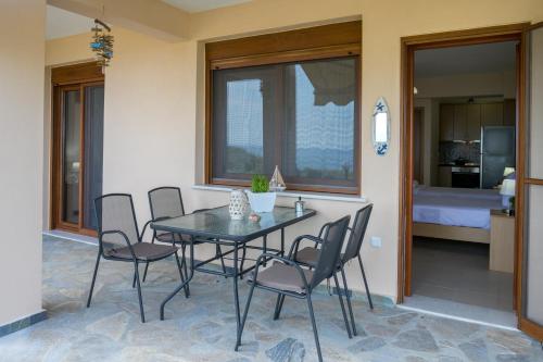 a dining room with a table and chairs and a bedroom at Aphrodite Villas in Kinira
