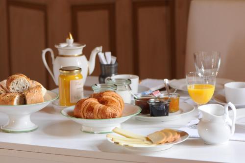 een ontbijttafel met croissants, brood en jus d'orange bij Domaine du Buc, Le Château in Marssac-sur-Tarn
