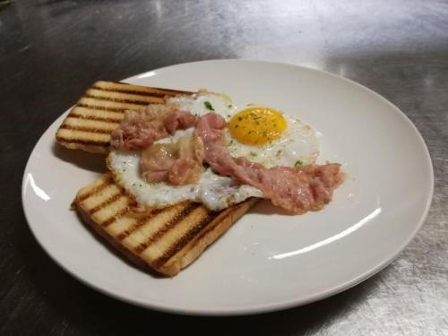 a white plate with an egg and ham on toast at Residenza L'Antico Borgo Hotel in Filadelfia
