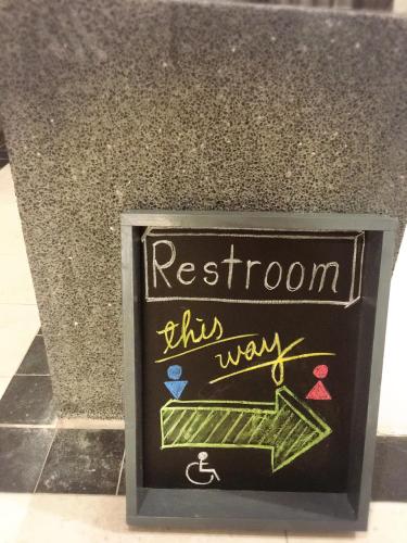 a sign that says restroom this way on a counter at Master Chitow Hostel in Kaohsiung