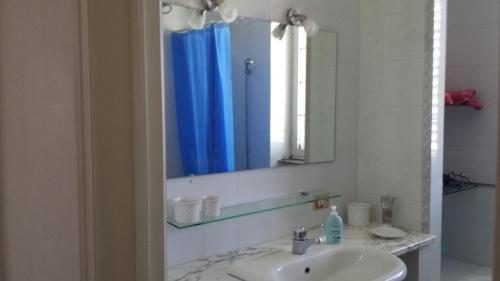 een badkamer met een wastafel en een spiegel bij Tenuta Schiauddi in Bagnolo del Salento