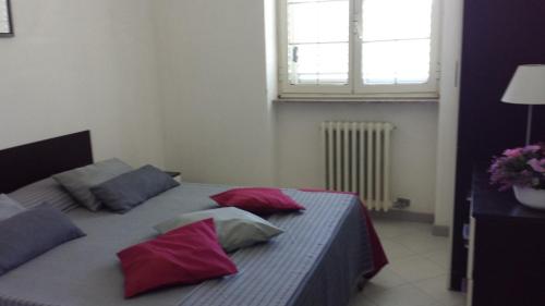 een slaapkamer met 2 bedden met rode kussens en een raam bij Tenuta Schiauddi in Bagnolo del Salento