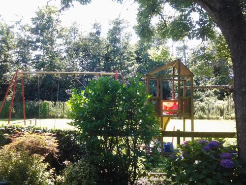 a playground in a park with a swing at Bed & Breakfast Meinsma in Moddergat