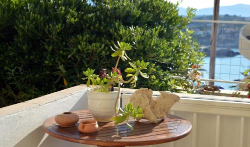 a wooden table with teddy bears and flowers on a balcony at Manos Apartments in Almirida