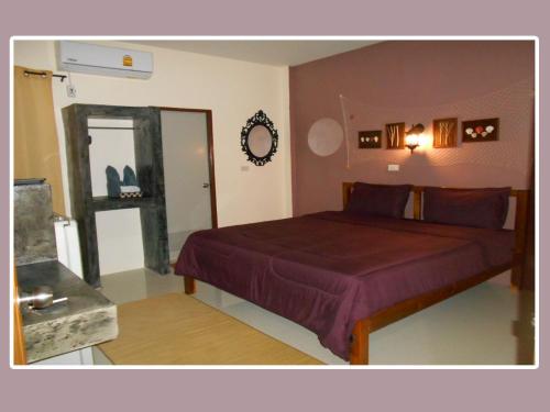 a bedroom with a bed and a mirror at The Miracle Guesthouse & Diving in Koh Tao