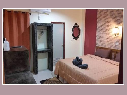 a bedroom with a bed with a stuffed animal on it at The Miracle Guesthouse & Diving in Koh Tao