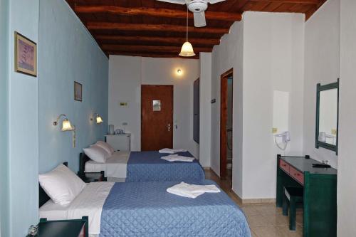 
a hotel room with a bed and a television at Faros Rooms in Loutro
