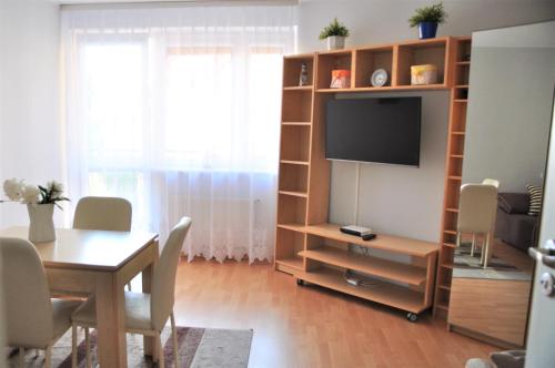 - un salon avec une table à manger et une télévision dans l'établissement Mieszkanie w Centrum Ustki, à Ustka