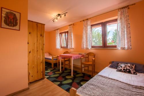 a bedroom with a bed and a table and chairs at Agroturystyka Pod Podkową in Mrągowo