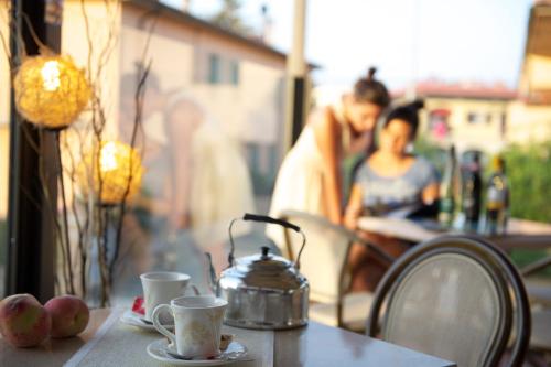 a table with two cups and a tea kettle on it at Holiday Rooms Antica Badia in Volterra