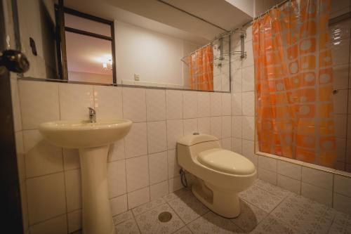 a bathroom with a toilet and a sink at Hotel Koricancha in Sicuani