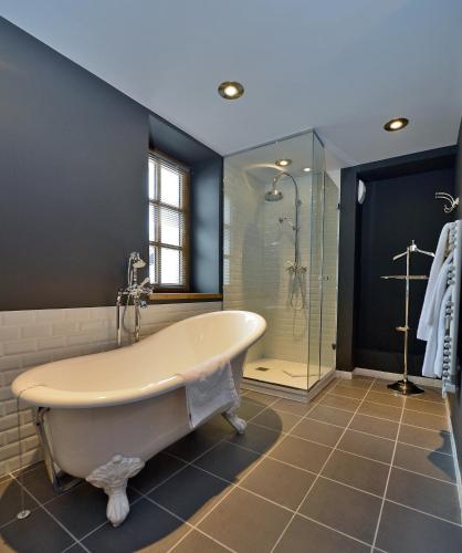 une grande salle de bain avec baignoire et douche dans l'établissement Maison de Famille Les 5 Frères, à Val dʼIsère