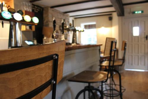 un bar dans un restaurant avec des tabourets de bar dans l'établissement The Hatch Inn, à Taunton