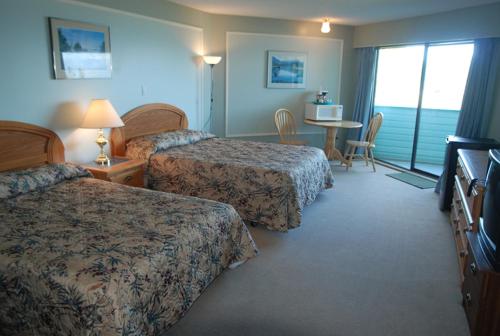 a hotel room with two beds and a table at North Shore Inn in Port Hardy