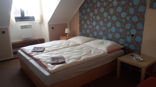 a bedroom with a bed with two towels on it at Hotel Veveří in Veverská Bítýška