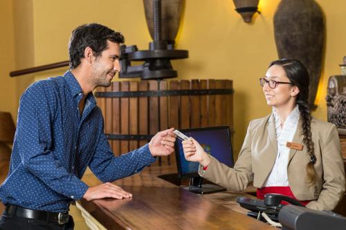 a man and a woman sitting at a table talking at Hotel Santa Cruz Plaza in Santa Cruz