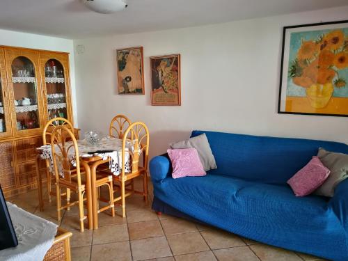 uma sala de estar com um sofá azul e uma mesa em Villa Caterina em Mondello