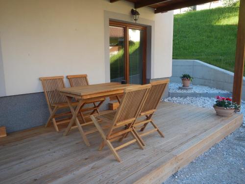 a wooden table and chairs on a wooden deck at Danijela & Gregor in Rateče