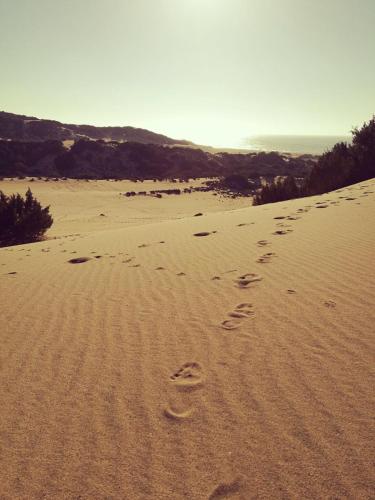 a pair of footprints in the sand on a beach at L'Oasi del Cervo in Arbus