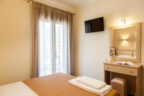 a bedroom with a bed and a mirror and a sink at Kavadias Apartments in Vasiliki