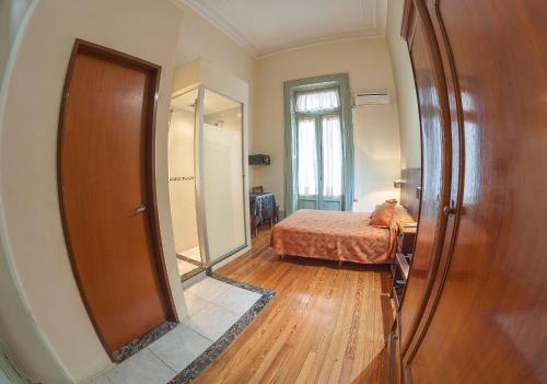 a bedroom with a bed and a large mirror at Hotel Reina in Buenos Aires