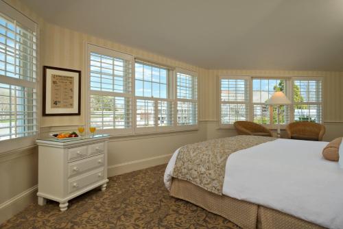 a bedroom with a white bed and windows at Chatham Wayside Inn in Chatham