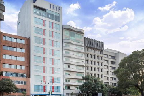 a tall white building with red windows at TRYP by Wyndham Mexico City World Trade Center Area in Mexico City