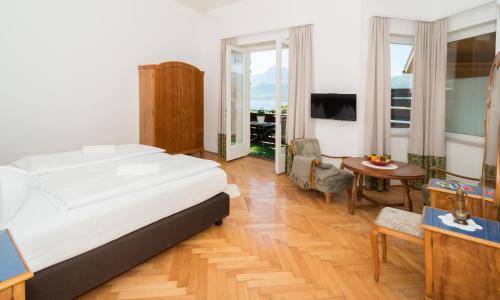 a bedroom with a bed and a living room with a table at Seehaus Familie Leifer in St. Wolfgang