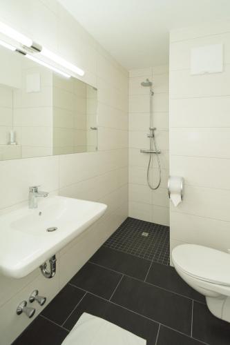 a white bathroom with a sink and a toilet at Seehaus Familie Leifer in St. Wolfgang