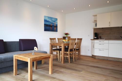 ein Wohnzimmer mit einem Sofa und einem Tisch sowie eine Küche in der Unterkunft Ferien im Hummelhaus in Lindau