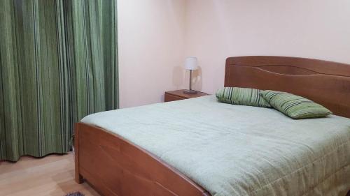 a bedroom with a large bed with a green curtain at Casa do Telheiro in Sabugueiro