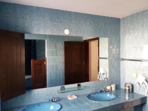 ein Badezimmer mit zwei Waschbecken und einem großen Spiegel in der Unterkunft Casa das Hortências By Alojamentos Vitinho - Vila Nova MIlfontes in Vila Nova de Milfontes