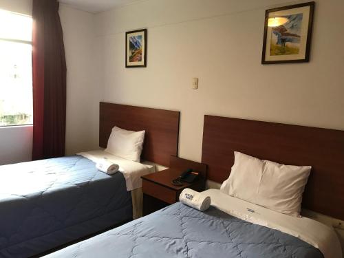 a hotel room with two beds and a window at Hostal Bond in Huaraz