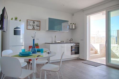 une cuisine avec une table et des chaises et une cuisine avec une fenêtre dans l'établissement Charlotte's House Locaz. Turistica, à Polignano a Mare