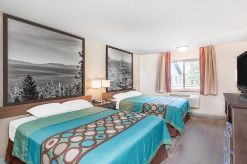 une chambre d'hôtel avec deux lits et une télévision à écran plat dans l'établissement Super 8 by Wyndham Redding, à Redding