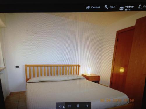 1 dormitorio con cama blanca y armario marrón en Casa vacanze "Le tre sorelle", en San Benedetto del Tronto