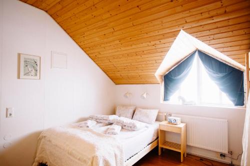 a bedroom with a bed and a large window at Skorrahestar in Neskaupstaður