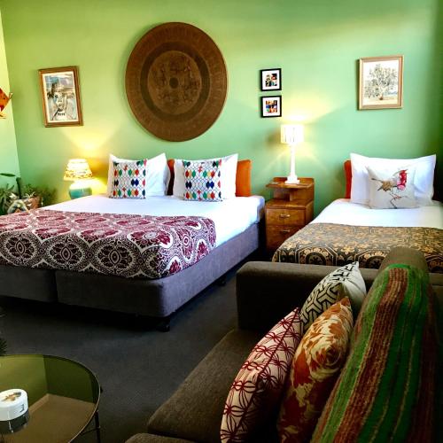 a hotel room with two beds and a couch at Vine Valley Inn in Cessnock