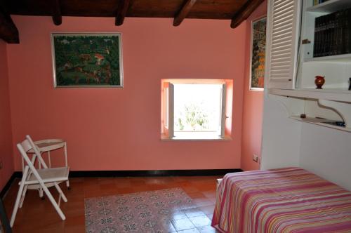 - une chambre avec des murs orange et une fenêtre dans l'établissement Appartamento di Villa Ellizabeth, à Milazzo