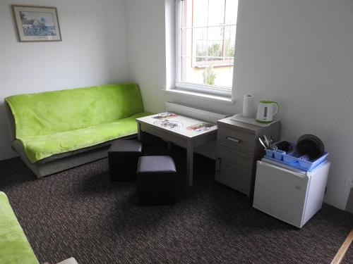 a room with a green couch and a table at Dom Wczasowy Pięciu Pomostów in Czaplinek
