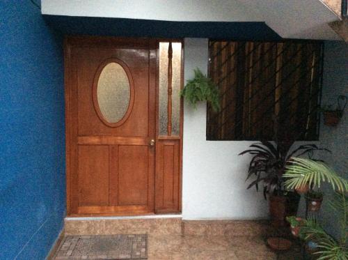 a wooden door of a house with a potted plant at B&B Cusing Wasi in Lima